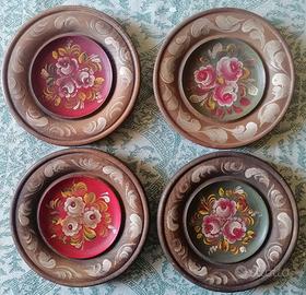 Quattro piatti da parete in legno dipinto a mano