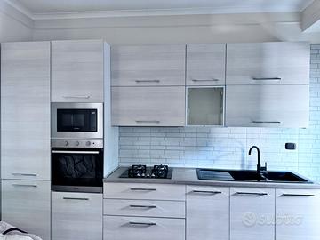 Cucina completa e arredo parete sala.