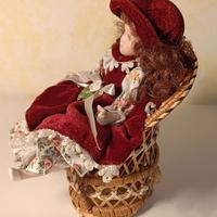 Bambola in ceramica con poltrona in vimini