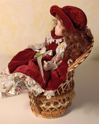 Bambola in ceramica con poltrona in vimini