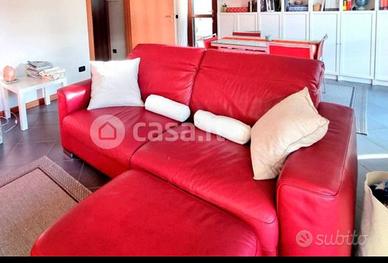 Divano letto Natuzzi in pelle rosso con pouf