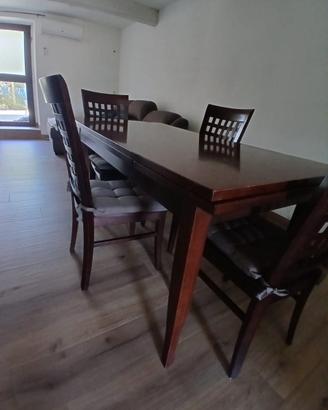 Tavolo allungabile in legno scuro con sedie abbina