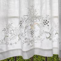 Tenda in lino finemente ricamata a mano.