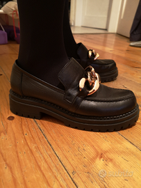 Mocassini neri in pelle con catena dorata