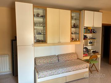 Armadio a ponte con letto, vetrine e scrivania
