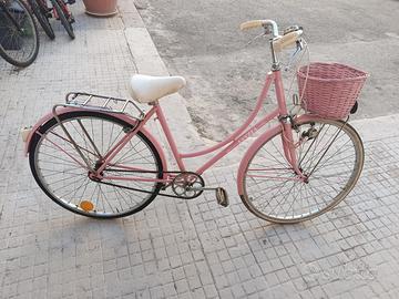 Bicicletta rosa con cestino e portapacchi