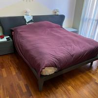 Letto matrimoniale con due comodini e comò.