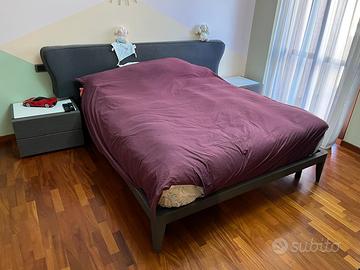 Letto matrimoniale con due comodini e comò.