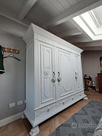 Armadio bianco a tre ante e tre cassetti.