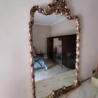 Specchio con cornice dorata.