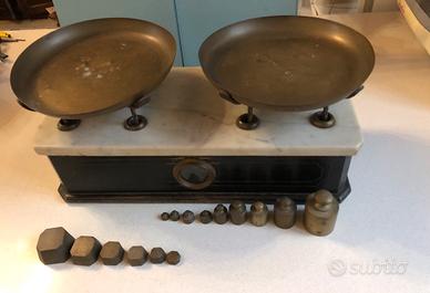 Bilancia antica due piatti con pesi