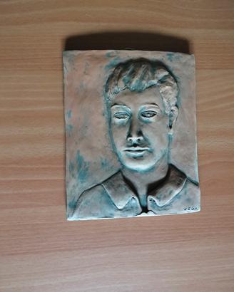 bassorilievo in terra cotta con volto di un uomo 