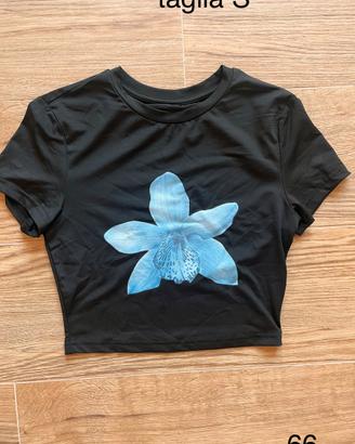 Crop top t-shirt nera con stampa orchidea azzurra