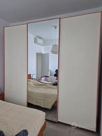 Armadio artigianale in legno con ampio specchio