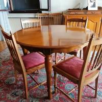 Tavolo rotondo con sedie e credenza