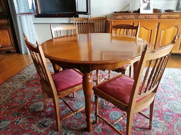 Tavolo rotondo con sedie e credenza