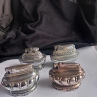 Quattro accendini da tavolo a benzina. 