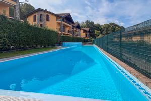 Trilocale con giardino , piscina , taverna e box