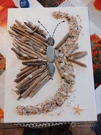 farfalla in legni di mare, sassi e conchiglie.