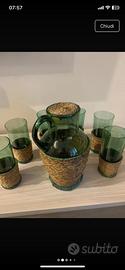 Bicchieri e caraffa in vetro verde con base vimini