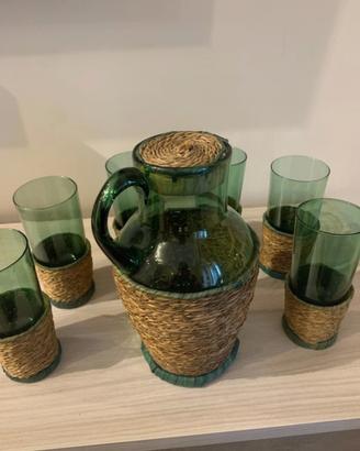 Bicchieri e caraffa in vetro verde con base vimini