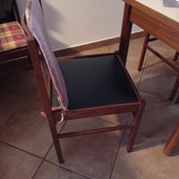 Tavolo con 5 sedie in legno e 2 divani.