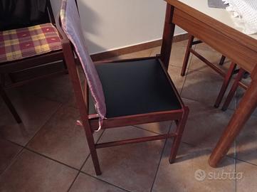 Tavolo con 5 sedie in legno e 2 divani.