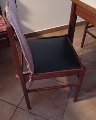 Tavolo con 5 sedie in legno e 2 divani.