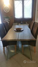 Tavolo in vetro con sedie marroni di complemento