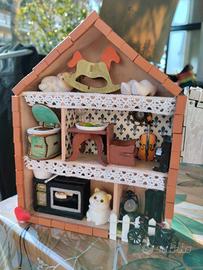 Casa delle bambole con gattini in bacheca.