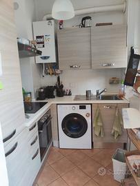 cucina angolare completa di elettrodomestici.