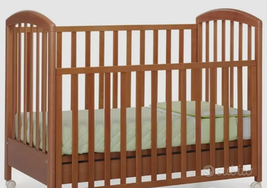 Lettino in legno scuro con materasso e lenzuolini