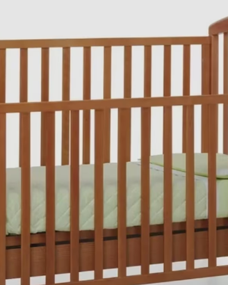 Lettino in legno scuro con materasso e lenzuolini