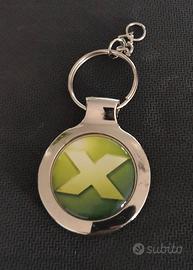 Portachiavi con scritta X su sfondo verde.