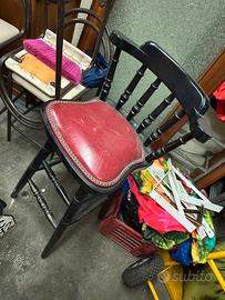 Sgabello in legno nero e seduta in pelle rossa.