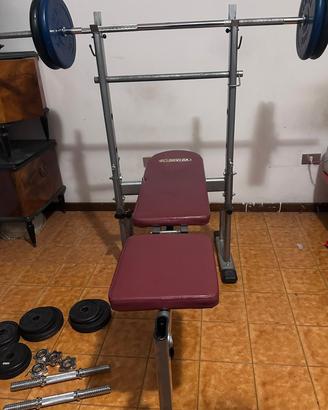 Panca piana con bilanciere e pesi 