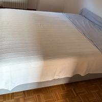 Letto matrimoniale con cassettone e materasso.
