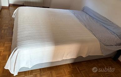 Letto matrimoniale con cassettone e materasso.