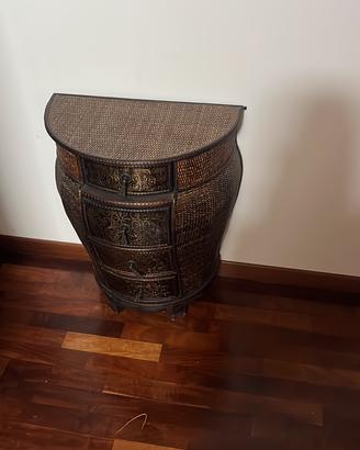 Un comodino/cassettiera a mezzaluna in vimini