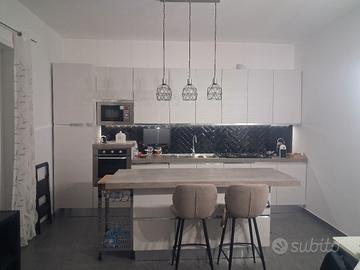 cucina con isola completa di elettrodomestici.