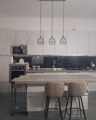 cucina con isola completa di elettrodomestici.