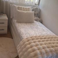 Letto singolo bianco con rete e cassetti.
