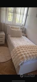 Letto singolo bianco con rete e cassetti.