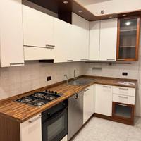 Cucina con elettrodomestici e tavolo e sedie