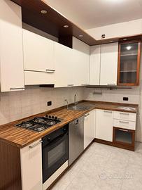 Cucina con elettrodomestici e tavolo e sedie