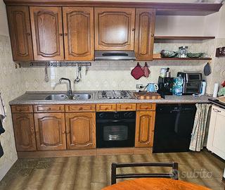 Cucina completa di elettrodomestici, tavolo, sedie