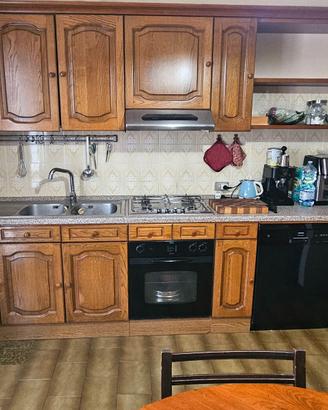 Cucina completa di elettrodomestici, tavolo, sedie