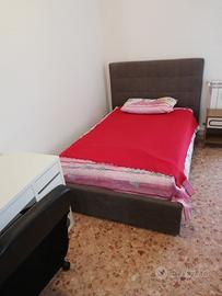 Stanza comoda arredata panoramica a letto singolo