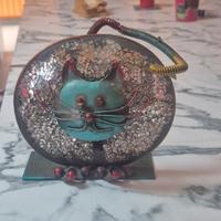 Gatto in ferro battuto illuminato da una candela