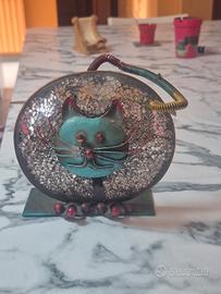 Gatto in ferro battuto illuminato da una candela